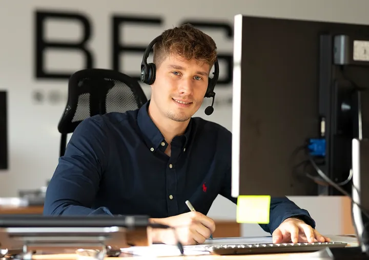 Ein Berater von TV4ALL am Schreibtisch mit Headset